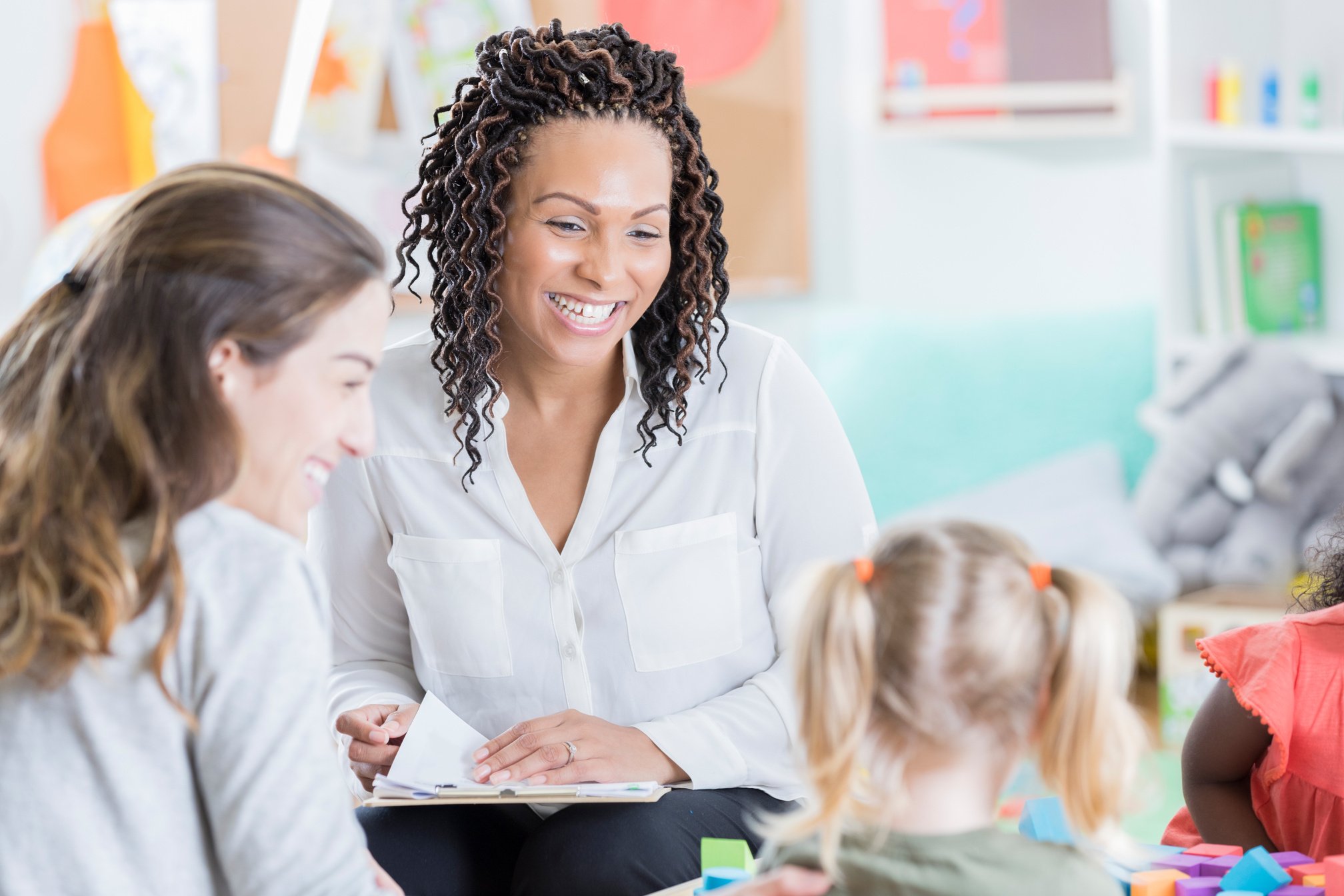 Preschool teacher holds parent teacher conferences